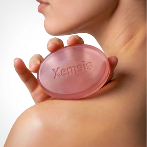 Person holding a pink Xemsis soap bar against skin